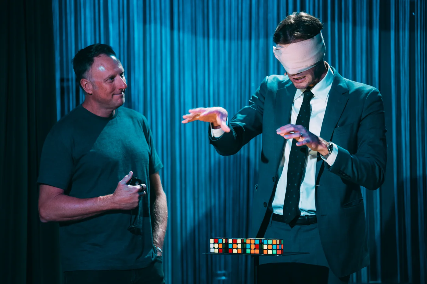 Kevin shares a moment of sleight of hand with a guest onstage
